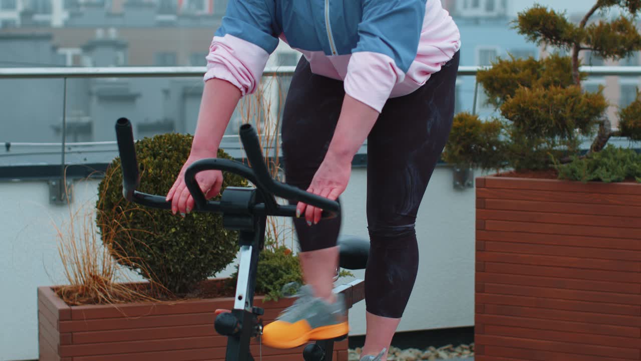 Woman performs aerobic endurance training workout cardio routine on the simulators cycle training