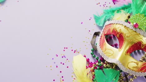 video of carnival masquerade mask, feathers, confetti and mardi gras beads, with copy space