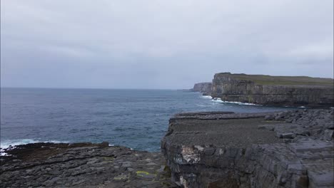 Terreno-Rocoso-En-La-Costa-De-Irlanda,-Agujero-De-Gusano-Inis-Mór,-Clima-Nublado-Y-Cambiante---Aéreo