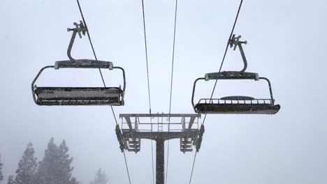 empty stationary empty ski lift chairs swinging in a heavy blizzard snowstorm