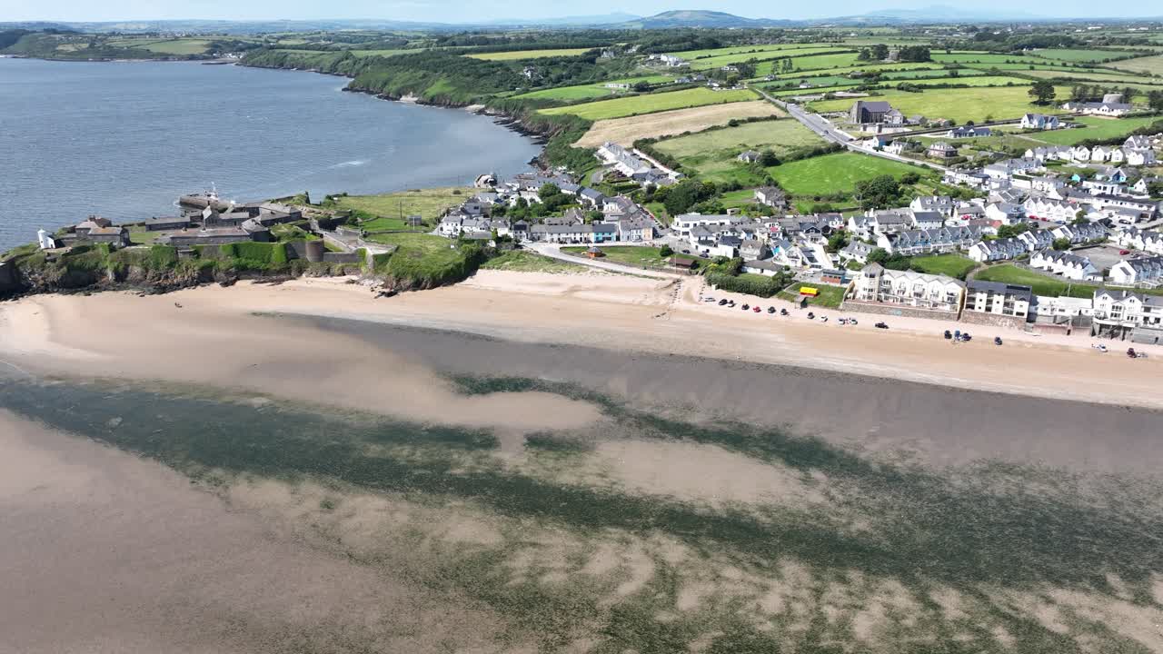 drone volando sobre el histórico fuerte y pueblo turístico de duncan en wexford, irlanda, en un cálido día de verano.