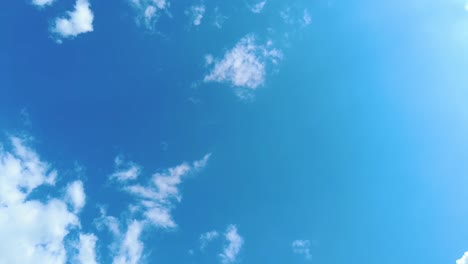 Sky-time-lapse-clouds-and-blue-sunny-sky,-Loop-of-white-clouds-over-blue-sky-with-sun-Rays,-Aerial-view,-drone-shooting-clouds-motion-time,-nature-blue-sky-a-white-clear-weather