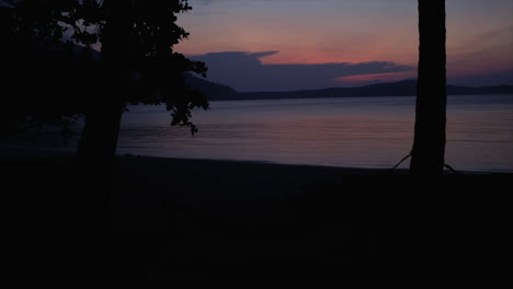 Una-Hamaca-Cuelga-Entre-Dos-Cocoteros-Durante-La-Puesta-De-Sol-Tomada-En-Una-Playa-En-Las-Islas-Perhentian,-Malasia