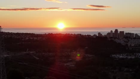 Imágenes-De-Drones-Panorámicos-De-Un-Impresionante-Amanecer-Amarillo-Y-Naranja-Sobre-El-Mar-Mediterráneo-En-Una-Mañana-Clara,-Con-La-Ciudad-De-Calpe,-España-En-Primer-Plano