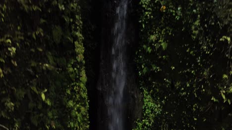 rainbow flare on pouring waterfall, pull up shot reveal village, bali