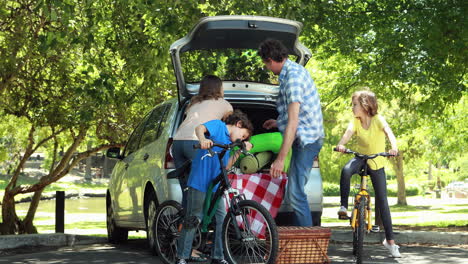 family unloading car trunk