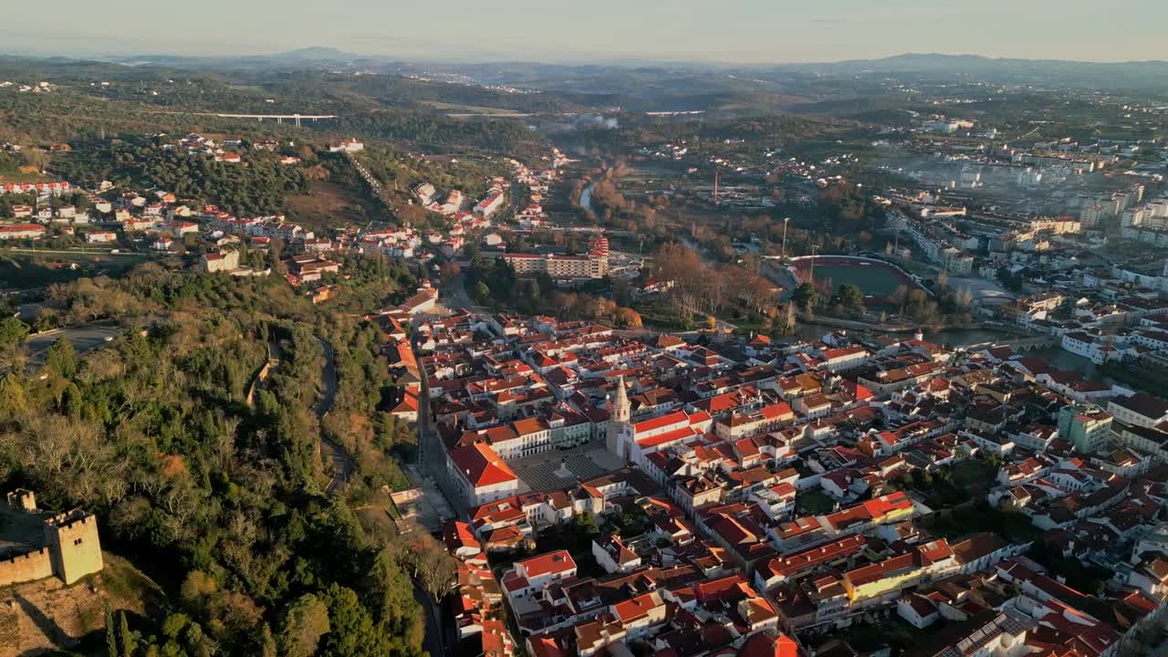 Den historiske by Tomar neden for bakkerne ved Kristusklosteret i Portugal. Tilbagetrækkende luftfoto.
