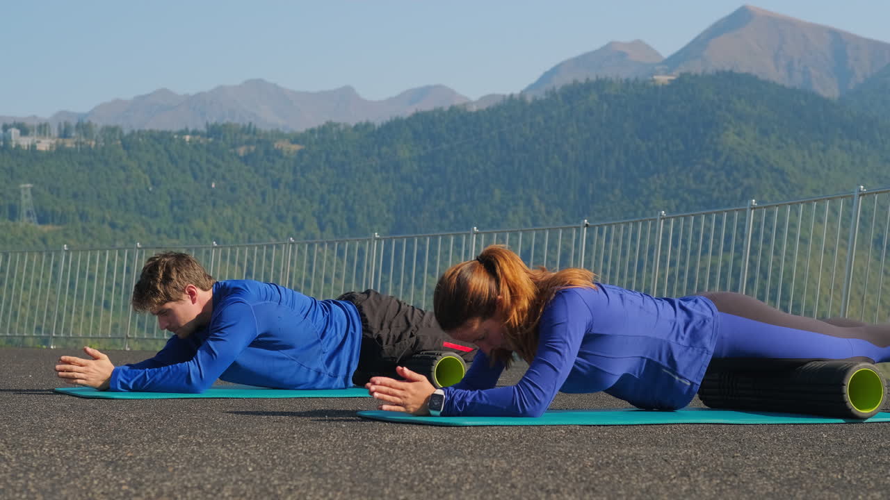 Couple Performing Foam Rolling Exercises Outdoors