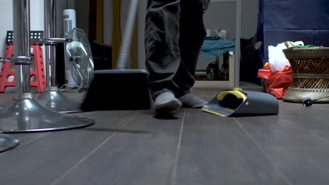 person brushing dust from office floor, low angle view below waist