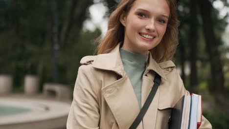 caucasian female student looking at the camera and smiling outdoors.