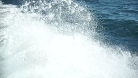 slowmo - close up of ocean sea white foamy waves behind boat