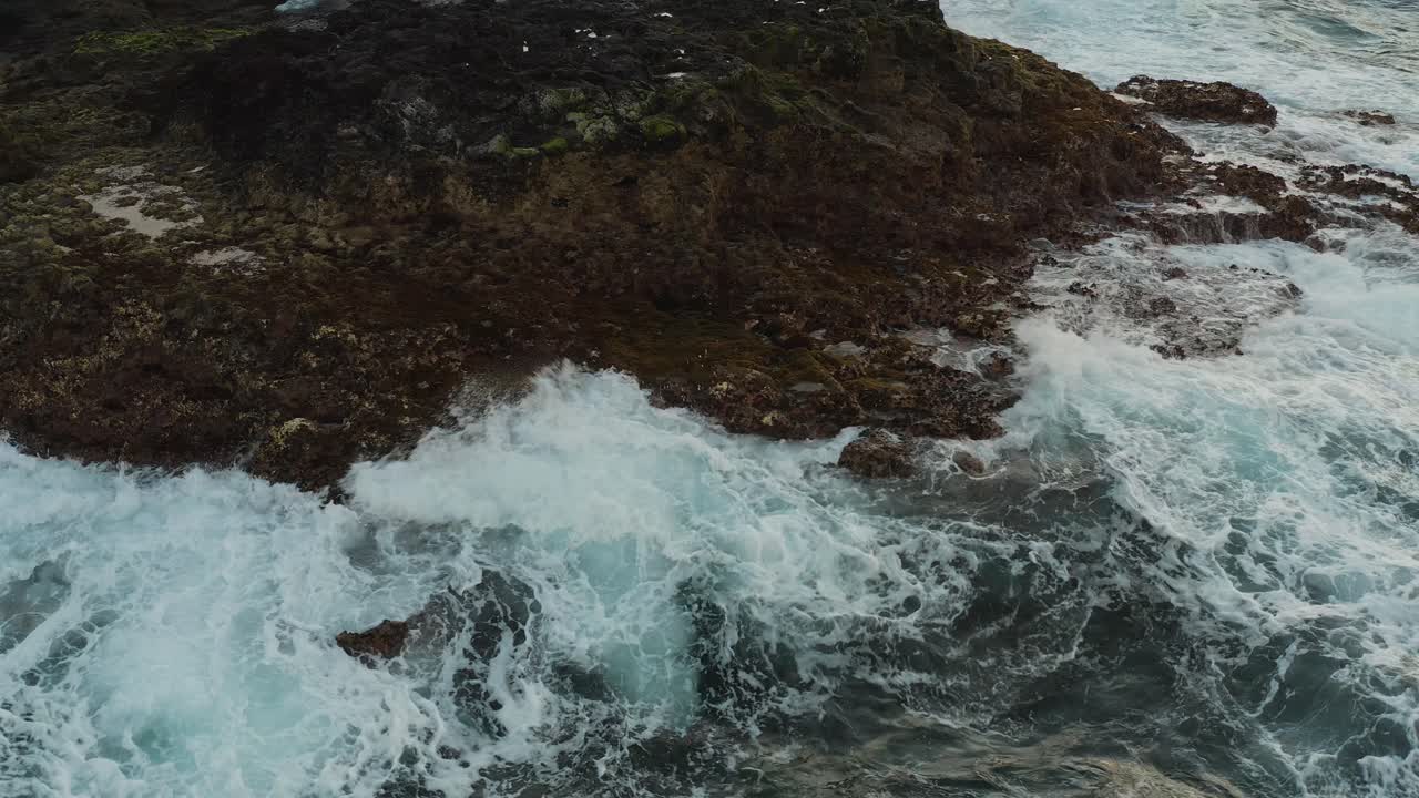 Ripresa ravvicinata con drone di onde che si infrangono sulla costa di un oceano