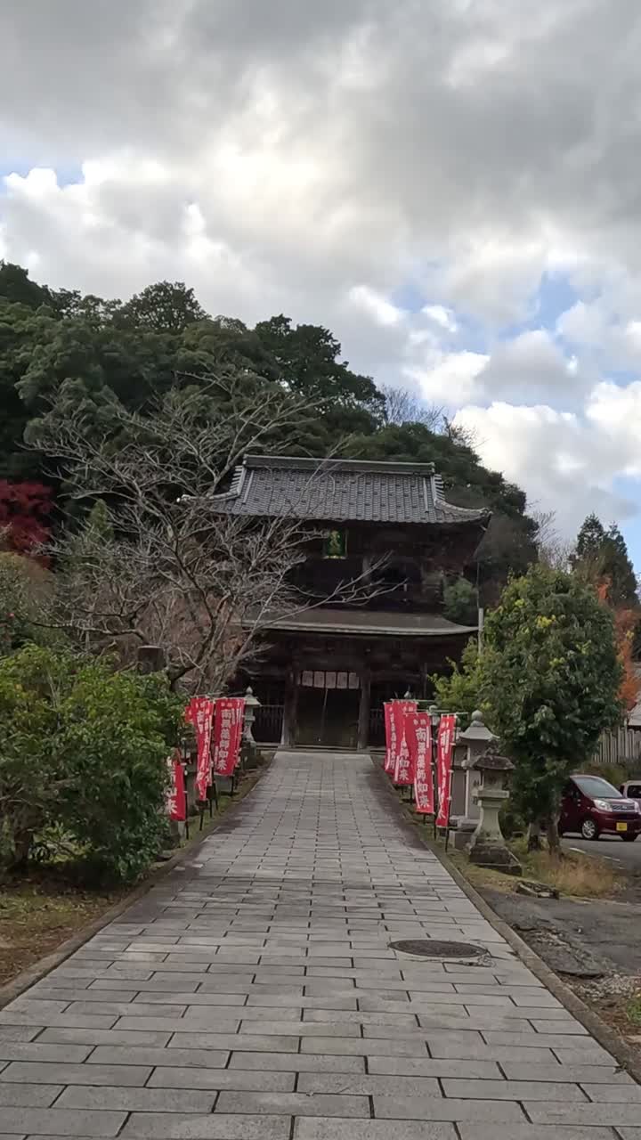 persona caminando hacia un santuario con banderas rojas