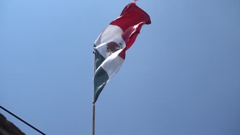 a mexican flag blowing in the wind on september