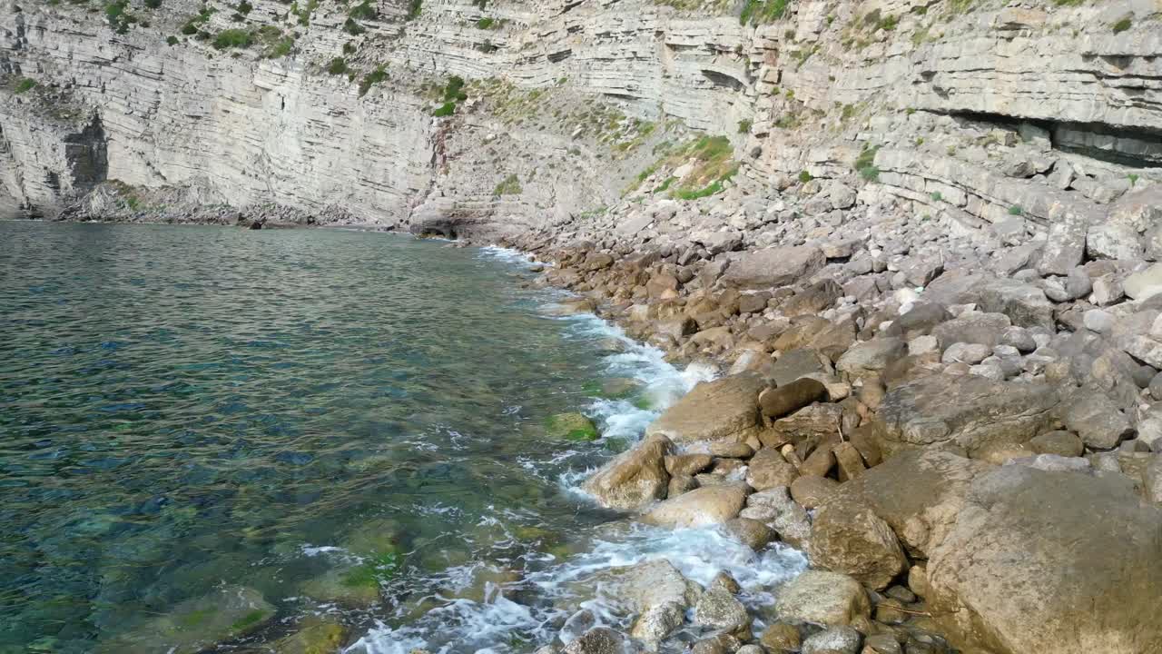 Transparent turquoise water flows between rocks in a bay in Ibiza, Spain. Wonderful aerial view flight overflight flyover drone