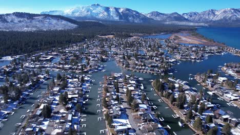 aerial view of tahoe keys on sunny winter day, homes in canals and snow capped peaks above lake tahoe, california usa