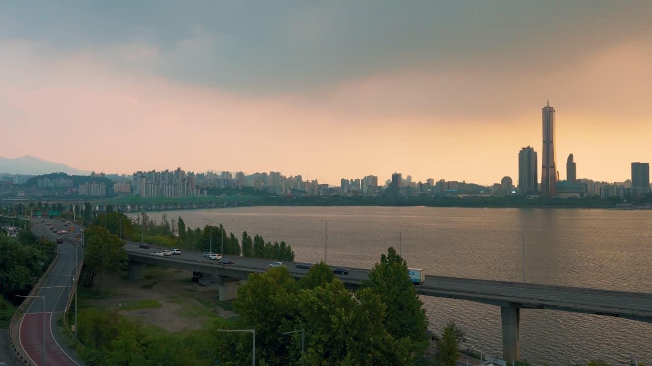 Evening Car Traffic by Han River on Gangbyeon Expressway with a View of 63 Building Skyscraper in Seoul Downtown, Yeongdeungpo District- real-time high angle