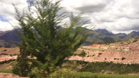 view of gorgeous green lush mountain and trees with cloudy blue sky above - wide shot