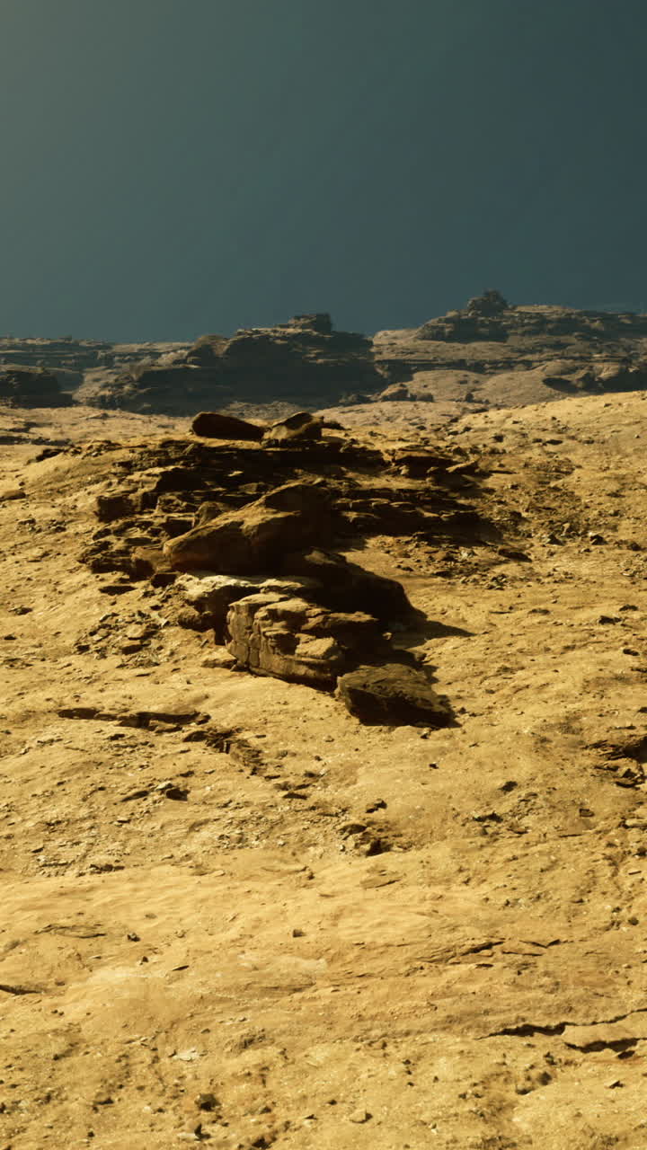 Orange rock formations under a clear blue sky at dusk near a canyon