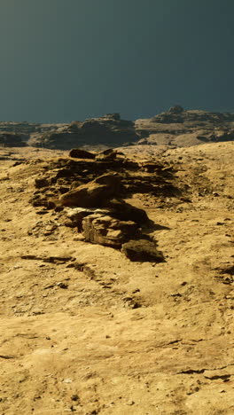 orange rock formations under a clear blue sky at dusk near a canyon