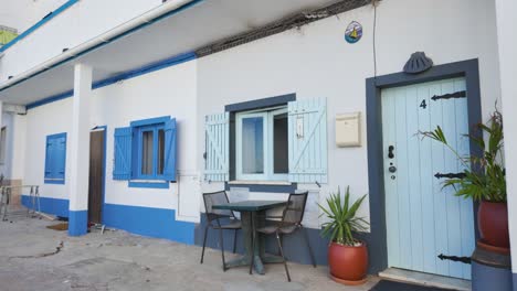 Charming-blue-and-white-coastal-house-with-outdoor-seating-and-potted-plants