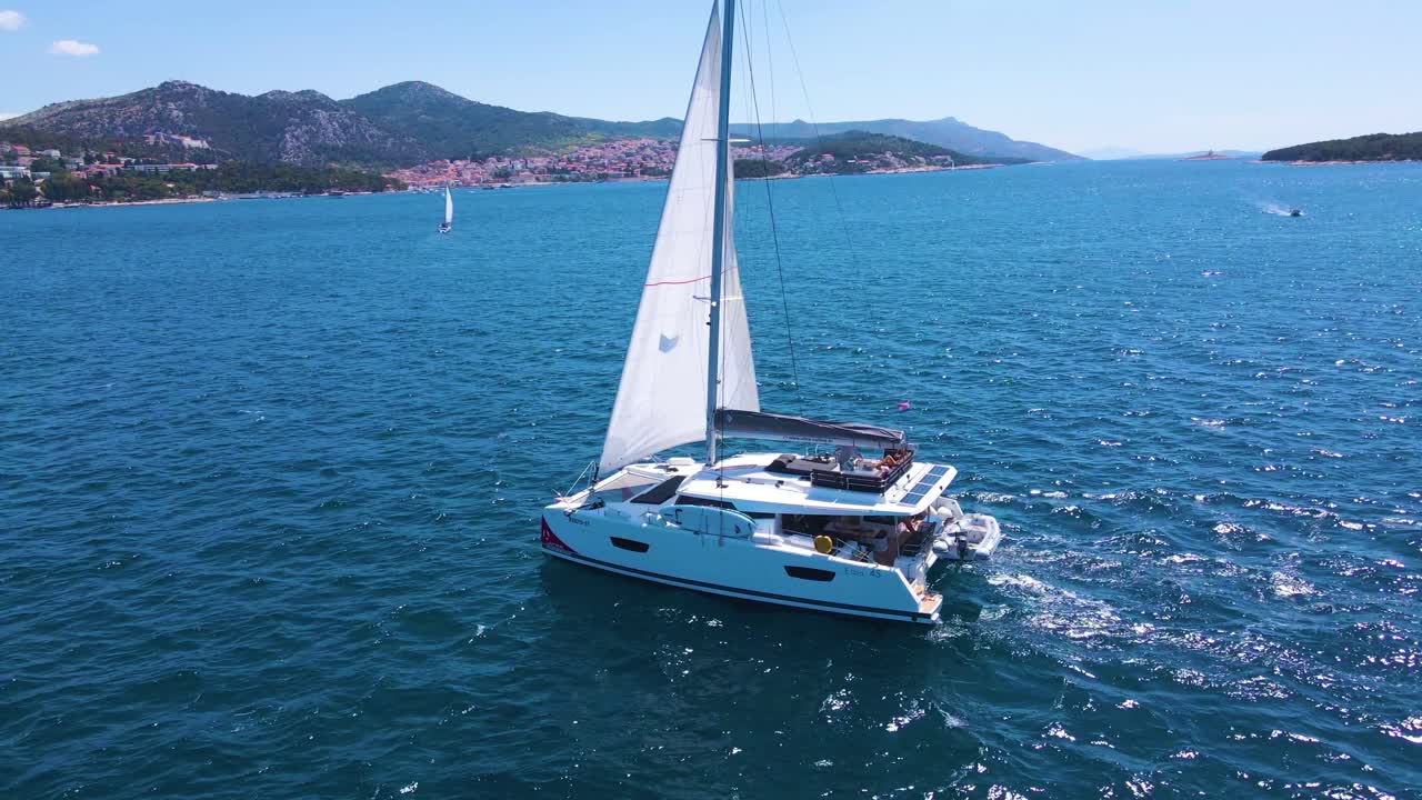 Drifting yachts in the bay near the coastal city of Croatia against the backdrop of blue skies and blue transparent water.