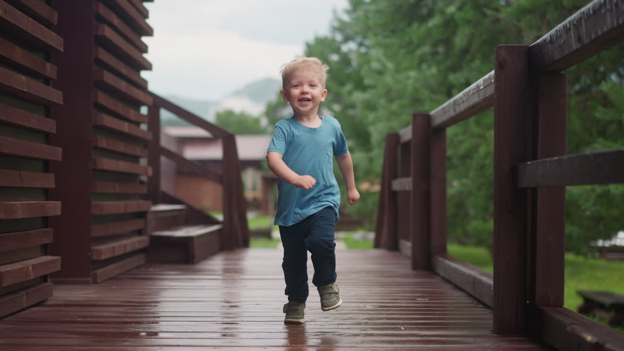 маленький мальчик бежит обнимать любящего родителя вдоль палубы веранды