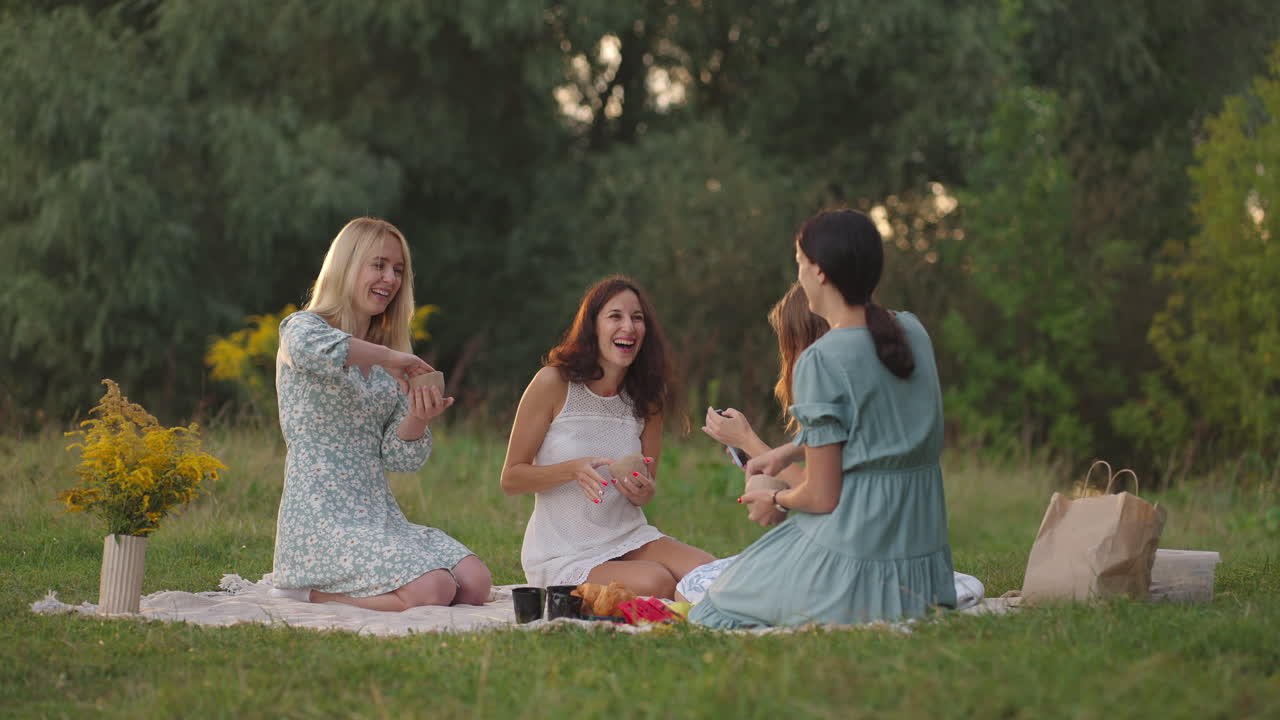 Open class joint creativity communication laughter common hobby women's circle. A group of young women in nature in the field in the park together sculpt from clay share their impressions.
