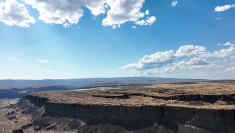 amplio tiro aéreo alejándose de los acantilados montañosos en ventajoso, washington