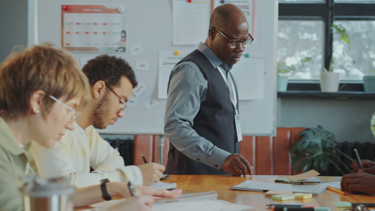 Teacher Helping Immigrant Students during Test in Language School