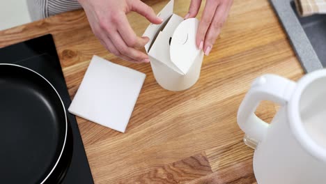 person opening a takeout food box with a healthy meal inside