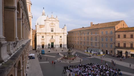large crowd gathers in piazza before basilica
