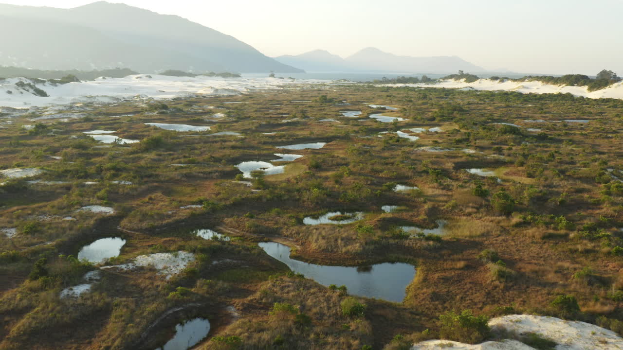 Vista aerea cinematografica con drone di lagune e dune di sabbia a Praia Da Joaquina, città di Florianopolis, Santa Catarina, Brasile