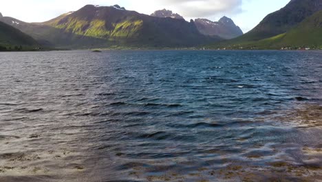 mujer con una bandera de noruega ondeando en el fondo de la naturaleza
