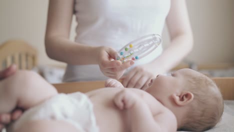 Lindo-Bebé-Se-Encuentra-En-La-Mesa-Para-Cambiar-Pañales-Y-La-Enfermera-Masajea-Las-Piernas