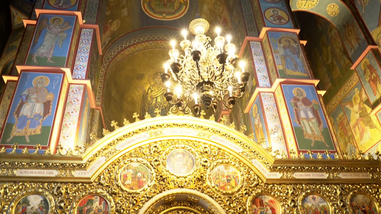 Ukraine,Kyiv,St.Michael Cathedral's interior,Camera moves from Jesus's fresco down towards to the apses and ground floor. A man with a mask and blue shirt crosses himself and kisses the fresco infront