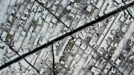 drone shot of the city of skardu from above, snow-covered and a road with cars