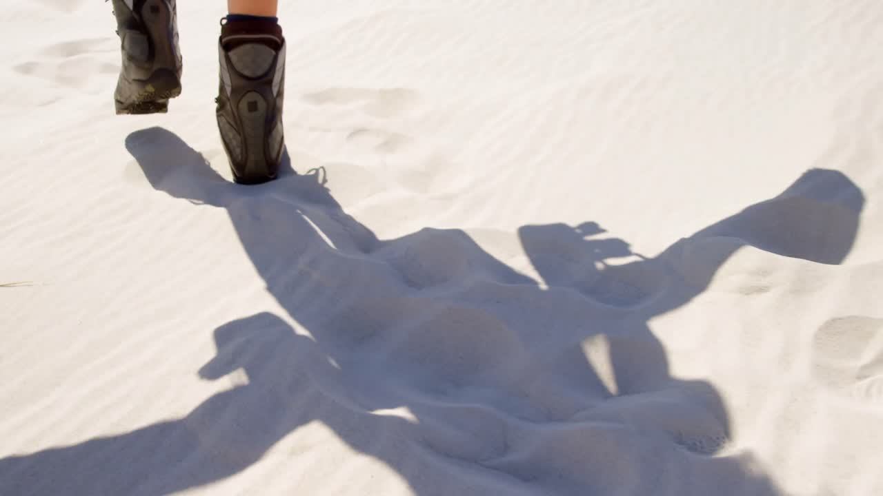 mujer con botas caminando en el desierto 4k