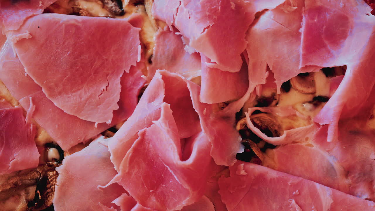 Overhead shot of a freshly baked pizza generously topped with thin slices of prosciutto