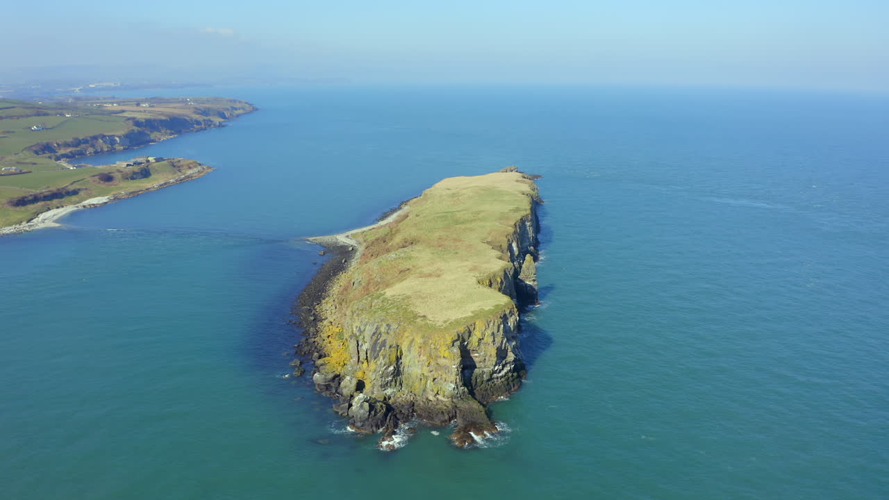 Aerial orbit of Portmuck Island, capturing its cliffs, shape, and coastal beauty
