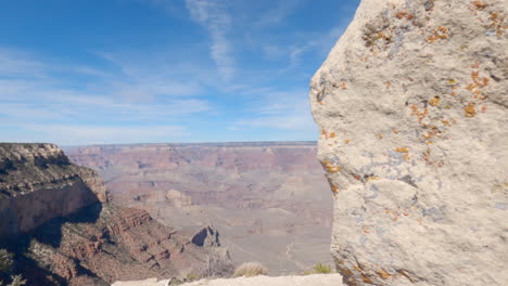 Reveal-panning-shot-of-the-Grand-Canyon-behind-a-Boulder