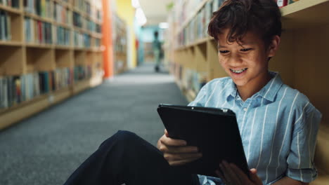 boy using tablet in library