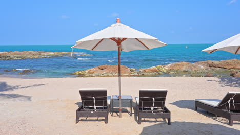 Tropisches-Urlaubskonzept,-Sonnenliegen-Und-Sonnenschirme-Am-Strand-Mit-Blick-Auf-Den-Horizont