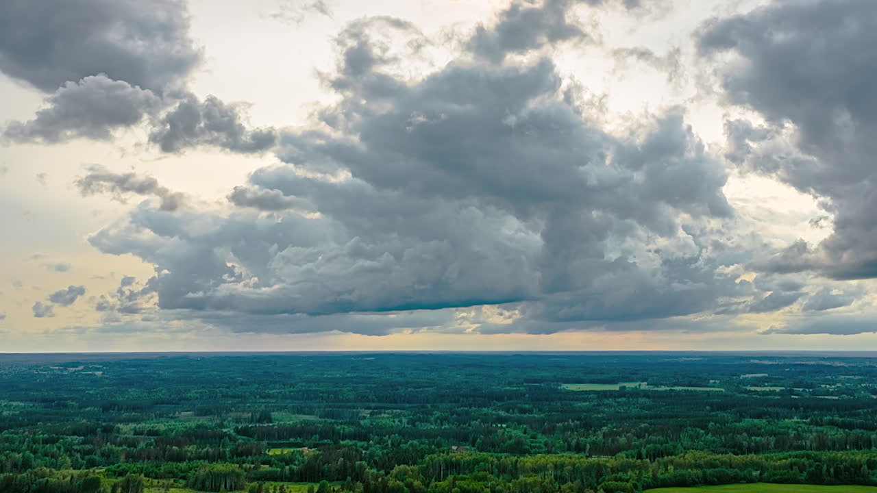 Dramatic clouds over lush landscape in hyperlapse sky shot