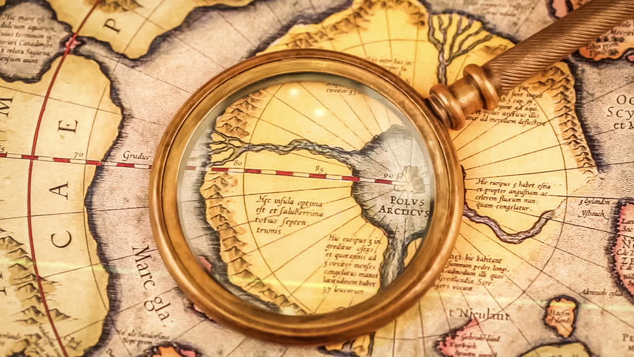 Vintage magnifying glass lies on the ancient map of the North Pole (also Hyperborea).
