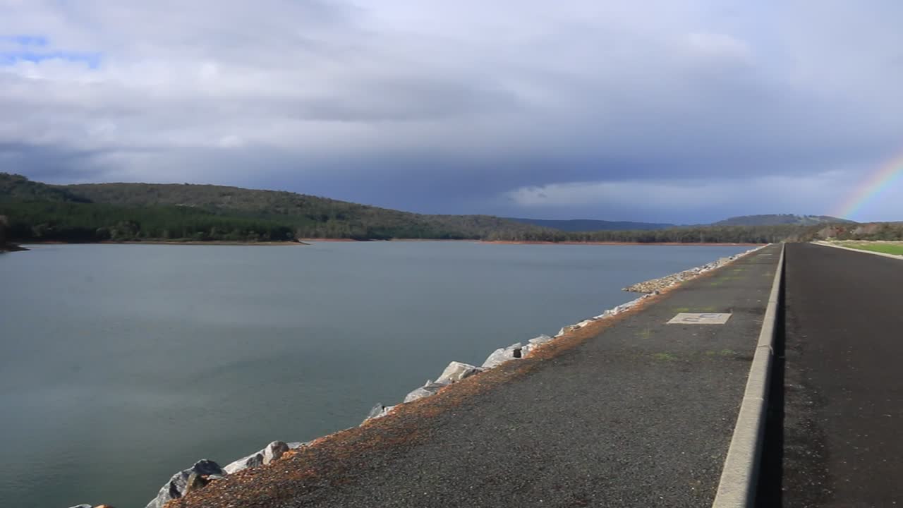 Pan Right Clip Overlooking Harvey Dam And Reervoir, With Rainbow Through Rainclouds