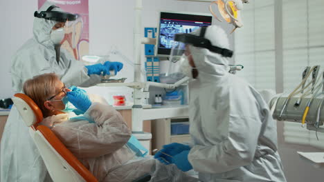 orthodontist in protective suit lighting the lamp until examination