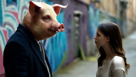 a man with a pig's head and a young woman