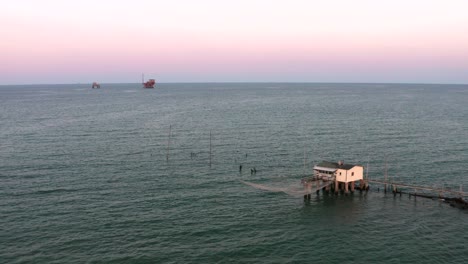 aerial shot of the valleys near ravenna where the river flows into the sea with the typical fishermen's huts at sunset