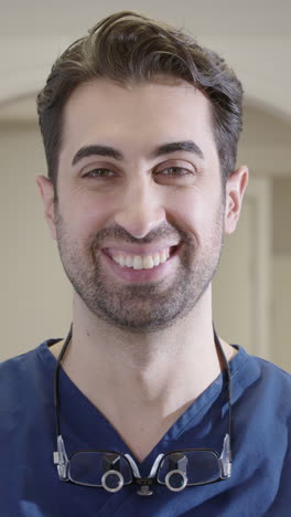 smiling healthcare professional making eye contact at workplace, vertical